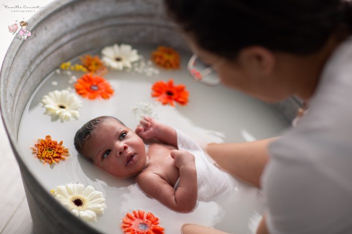 bebe dans un bain de lait avec fleurs