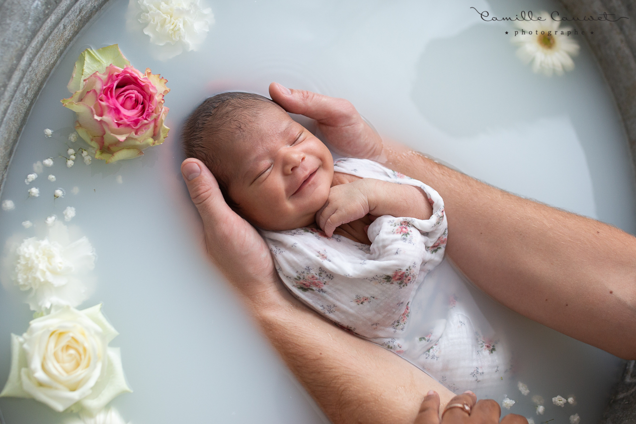 bébé dans bain de lait enveloppé fleuri